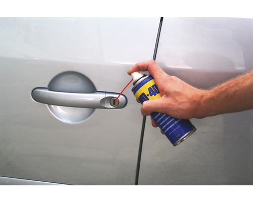 WD-40 Sprühdose wird in ein Autoschloss gesprüht