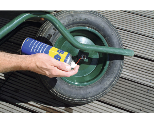 WD-40 Multifunktionsprodukt wird auf ein Schubkarrenrad aufgetragen.