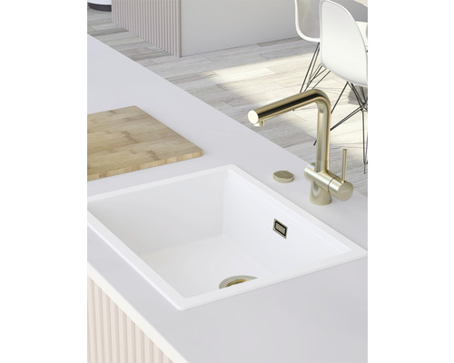 Küchenspüle mit Armatur und Schneidebrett auf einer Arbeitsplatte.