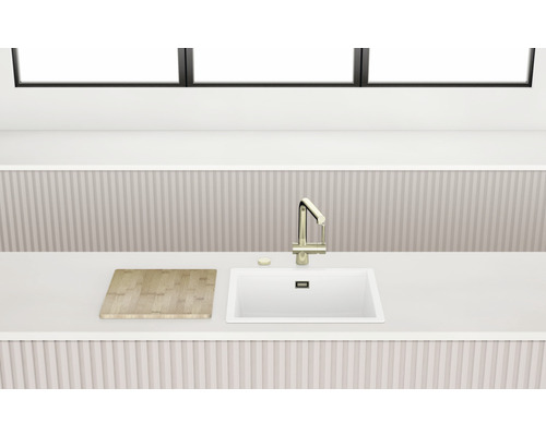 Küchenspüle mit Wasserhahn und Schneidebrett auf einer Küchentheke.