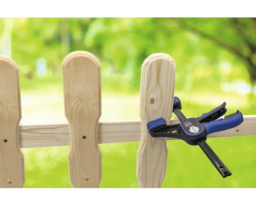 Holzzaun wird mit einer Einhandzwinge befestigt