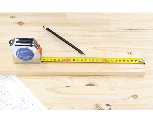 Bandmaß, Bleistift und Holzbrett auf Holztisch