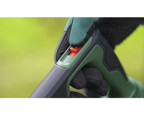 Detailaufnahme der Handhabung eines Gartengeräts mit rotem Schalter