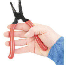 Hand hält eine Abisolierzange mit roten Griffen.