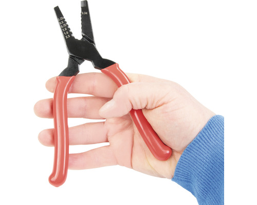 Hand hält eine Abisolierzange mit roten Griffen.