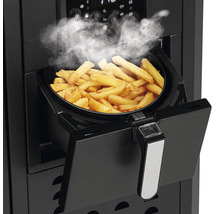 Heißluftfritteuse mit dampfenden Pommes Frites im Korb