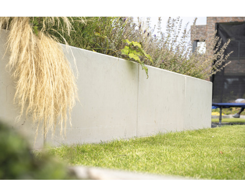 Beton-Pflanzkasten im Garten mit Gras und Pflanzen