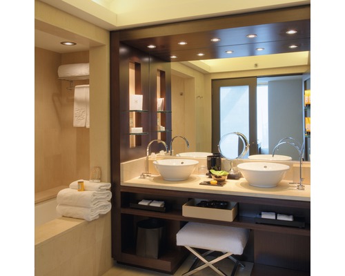 Badezimmer mit Doppelwaschbecken, Spiegel und Handtüchern.