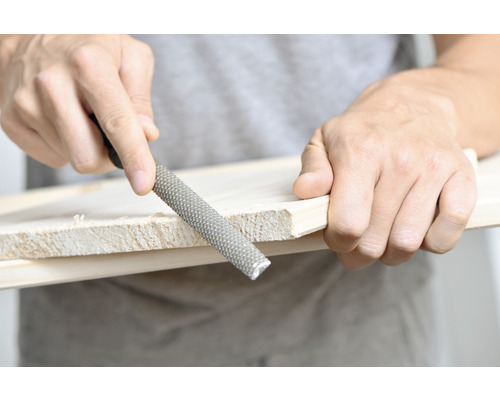 Eine Holzraspel wird zum Bearbeiten eines Holzstücks verwendet.