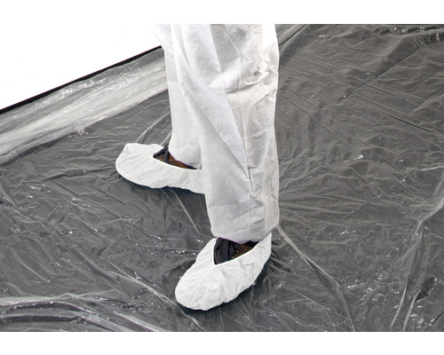 Person mit Schutzanzug und Schuhüberziehern auf transparenter Folie