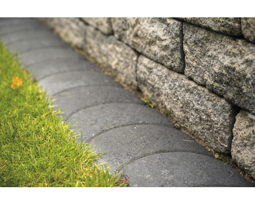 Steinmauer mit Rasenfläche und gepflastertem Weg