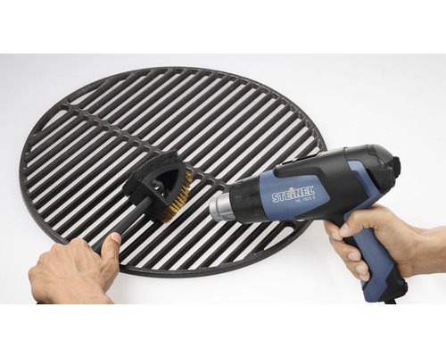 Grillrost wird mit Bürste und Heißluftpistole gereinigt