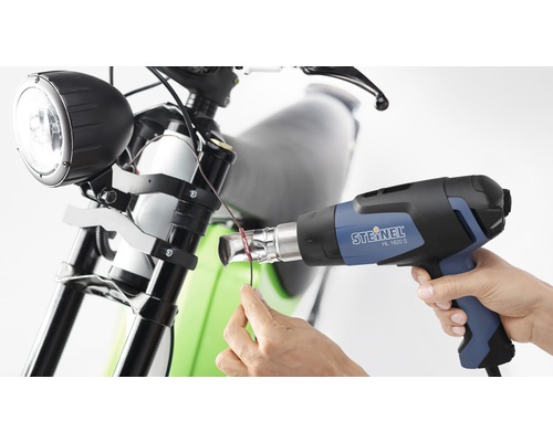 Heißluftpistole beim Schrumpfen eines Kabels am Motorrad