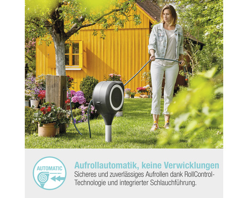 Frau benutzt Schlauchaufroller im Garten
