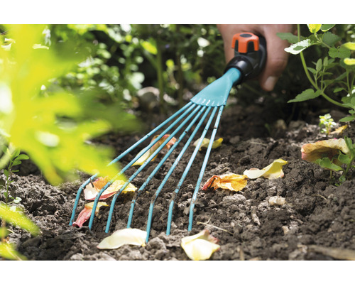 Gartenrechen beim Entfernen von Laub aus der Erde.