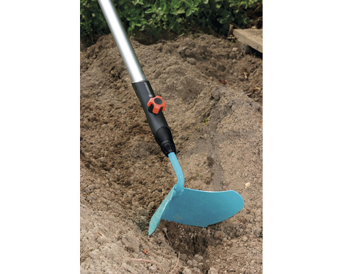 Gartenhacke mit Stiel im Einsatz im Gartenboden.