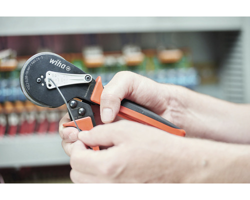 Eine Person verwendet eine Wiha Crimpzange zum Crimpen eines Kabels