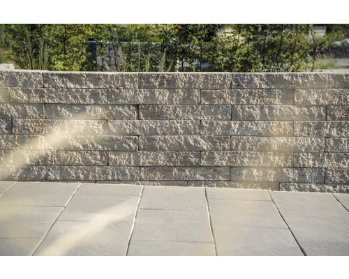 Mauer aus Natursteinen und Bodenplatten