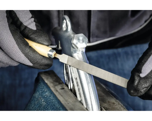 Eine Metallfeile mit Holzgriff in der Anwendung zum Bearbeiten eines Werkstücks im Schraubstock.