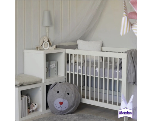 Kinderzimmer mit Gitterbett, Regalwürfeln und Bärenkissen