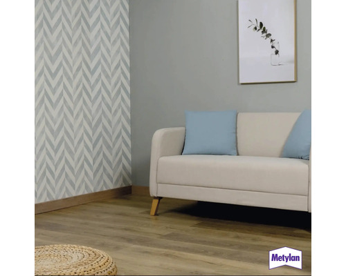 Wohnzimmer mit Sofa, Kissen und Wandgestaltung mit grafischem Muster