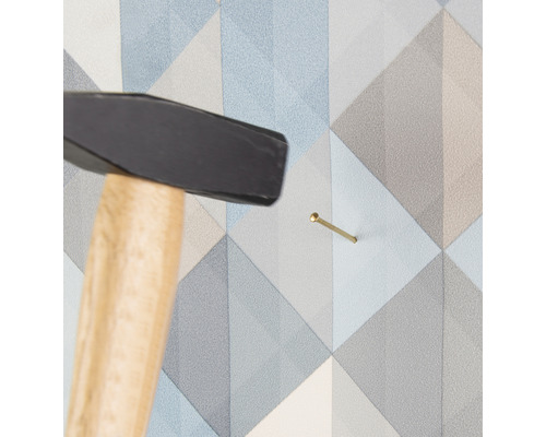 Hammer schlägt Nagel in Wand