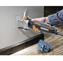Eine Hand bedient ein Multifunktionswerkzeug von Worx zum Schneiden einer Öffnung in eine Metallwand.