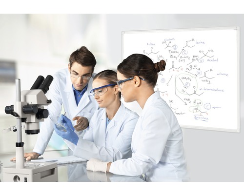 Drei Wissenschaftler in einem Labor mit einem Mikroskop und einer Whiteboard-Tafel mit chemischen Formeln.