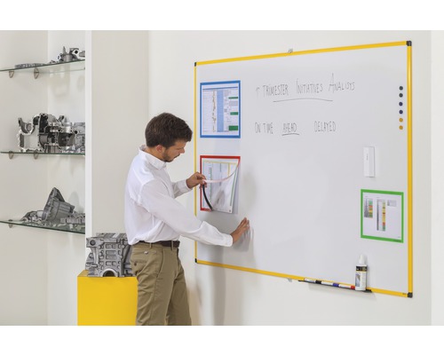 Ein Mann interagiert mit einer Whiteboard-Organisationstafel mit magnetischen Dokumentenrahmen für das Büro