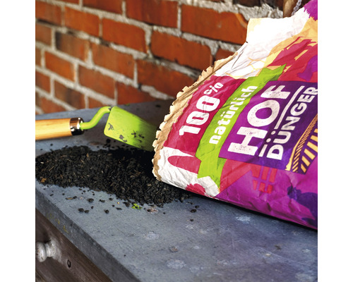 Hofdünger Sack mit Gartenschaufel und Düngerhäufchen