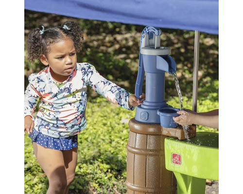 Mädchen spielt mit einem Step2 Wasserspieltisch im Freien