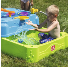 Junge spielt mit einem Step2 Wasserspieltisch im Garten