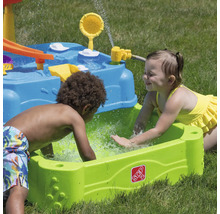 Zwei Kinder spielen mit einem Step2 Wasserspieltisch im Garten.