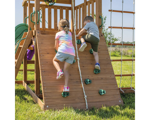 Zwei Kinder klettern auf einer hölzernen Kletterwand mit Griffen.