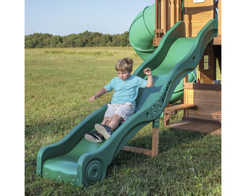 Junge rutscht auf einer grünen Kinderrutsche.