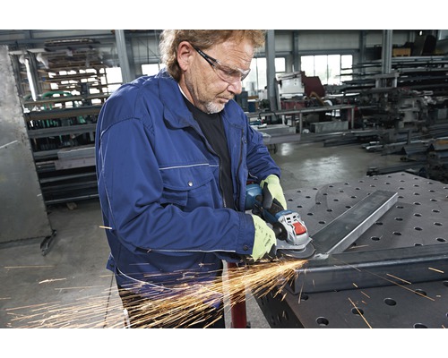 Ein Mann schleift Metall mit einem Winkelschleifer.