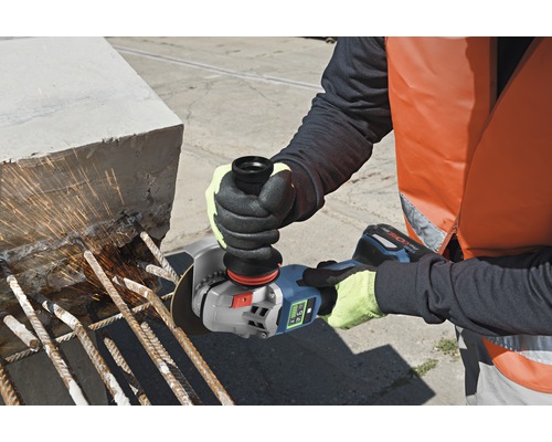 Eine Person verwendet einen Akku-Winkelschleifer zum Schneiden von Metallstangen in Beton.