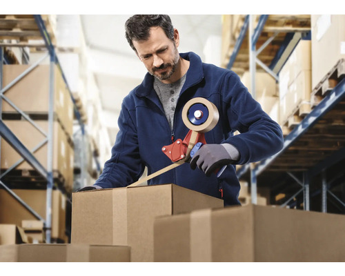Ein Mann verschließt einen Karton mit einem Klebebandabroller in einem Lager.
