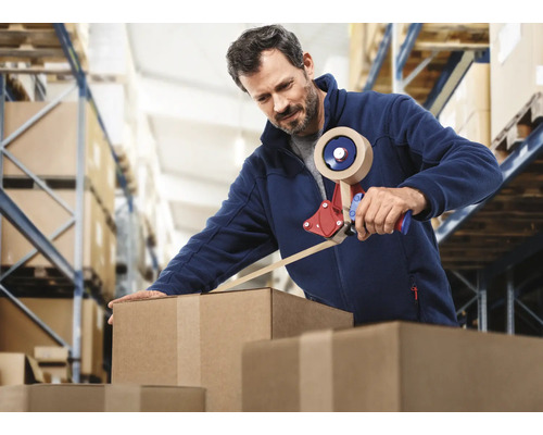 Mann verpackt Kartons mit einem Handabroller in einem Lager