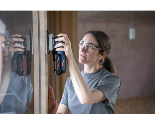 Frau arbeitet mit einem Bosch Multifunktionswerkzeug an einem Holzrahmen