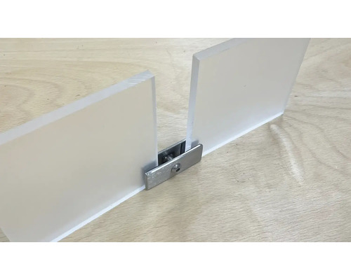 Zwei Acrylglasplatten verbunden mit einem Metallverbinder auf einer Holzoberfläche