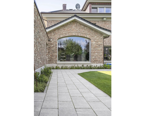 Gepflasterter Weg im Garten mit Rasenfläche