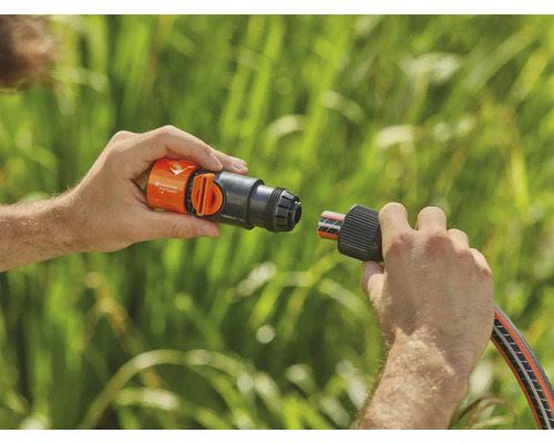 Eine Person verbindet ein Gardena Schlauchstück mit einem Wasserhahnanschluss.