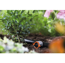 Gartenbewässerungssystem mit Tropfer und Pflanzen im Gartenbeet