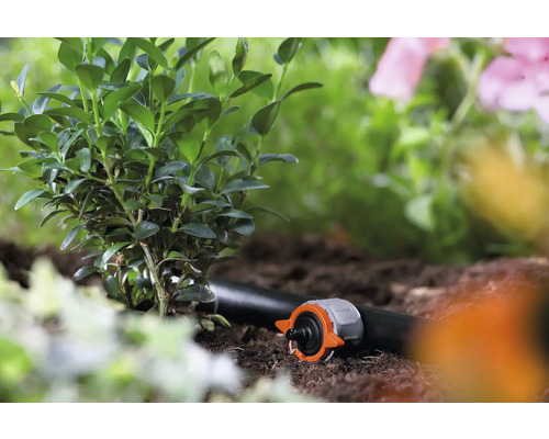 Gartenbewässerungssystem mit Tropfer und Pflanzen im Gartenbeet