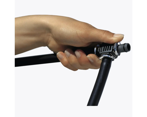 Hand hält eine Gartenbewässerungsrohrverbindung