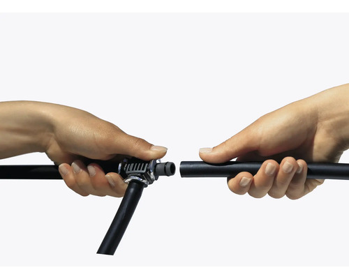 Zwei Hände verbinden einen Bewässerungsschlauch mit einem Verbindungsstück.