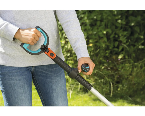 Person hält einen Unkrautstecher mit Griff und Handgriff.