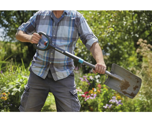 Eine Person hält einen Gardena Spaten im Garten.