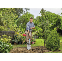 Mann gräbt mit Spaten im Garten